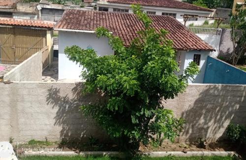 a tree in front of a white building at Hospedaria Recanto do Bem-te-vi - Kitinete e suite in Serra
