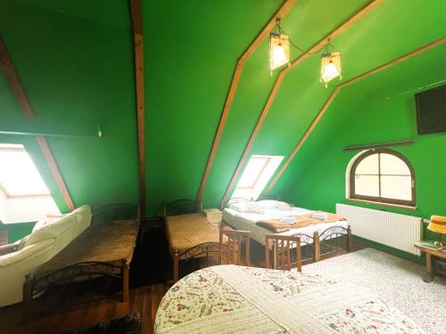 a green room with two beds and a table at Penzion Kersko in Hradišťko
