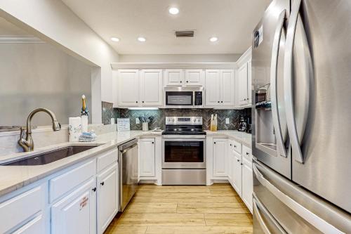 a kitchen with white cabinets and a stainless steel refrigerator at Tivoli Terrace 5435 in Destin