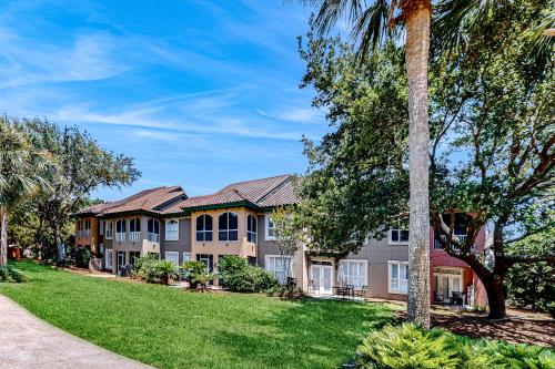 a large house with palm trees and a lawn at Tivoli Terrace 5435 in Destin