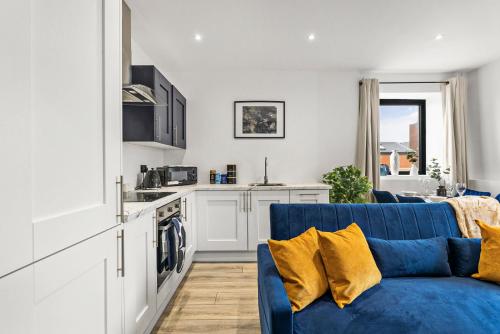 a living room with a blue couch and a kitchen at Comfortable 2-Bedroom Stay in Norwich in Norwich
