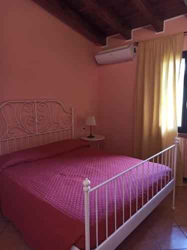 a bedroom with a bed with purple sheets and a window at Omas Haus in Toscolano Maderno