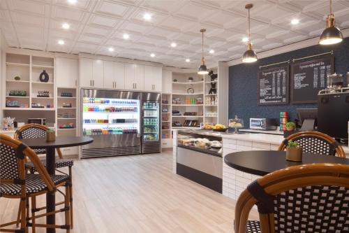 Una cocina con dos mesas y un refrigerador. en Hilton Dallas Southlake Town Square, en Southlake