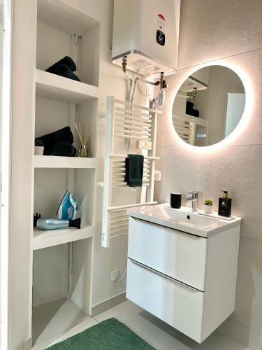 une salle de bain avec un lavabo blanc et un miroir dans l'établissement Studio Cosy à Nice Centre, à Nice