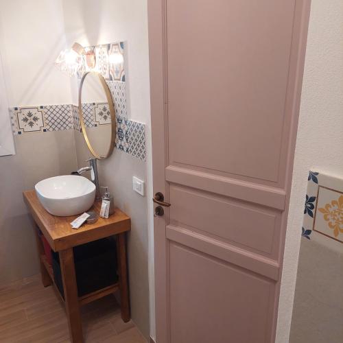 a bathroom with a sink and a mirror and a door at MareAura in Trapani