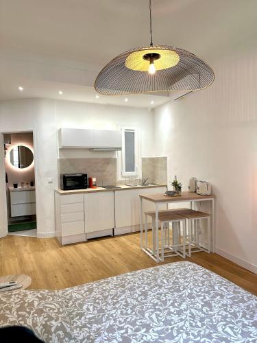 une cuisine avec des armoires blanches et une table dans une pièce dans l'établissement Studio Cosy à Nice Centre, à Nice