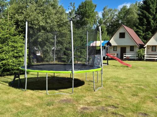 a trampoline in a yard with a playground at Domki Letniskowe Bryza in Jarosławiec
