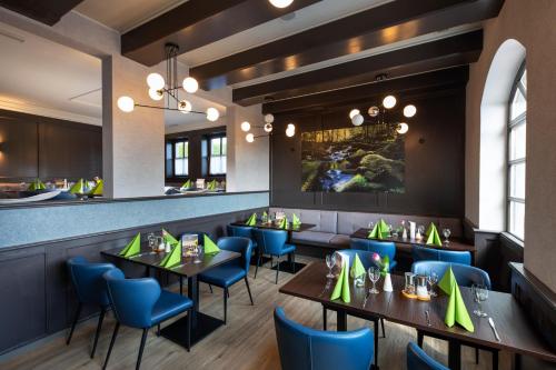 a restaurant with tables and chairs and a bar at Hotel am Badepark Waldkirchen in Waldkirchen