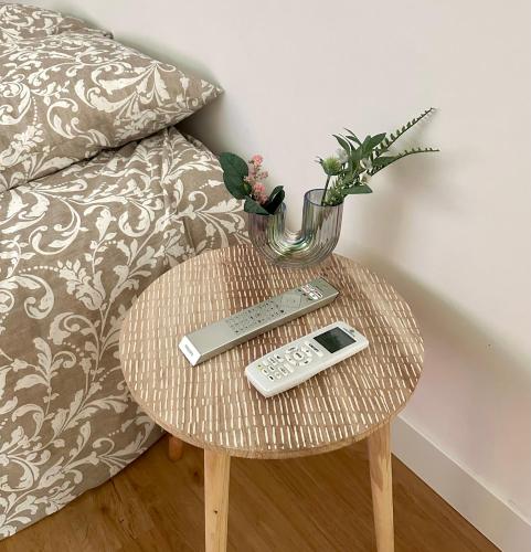 une table avec télécommande et un vase sur celle-ci dans l'établissement Studio Cosy à Nice Centre, à Nice