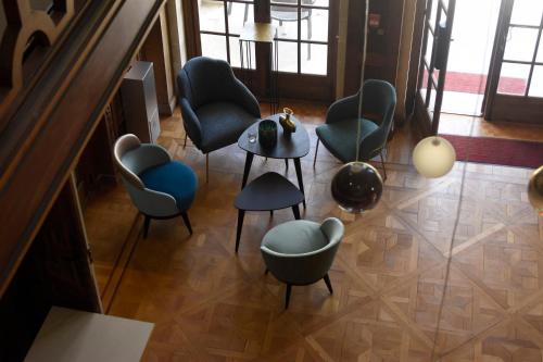 a group of chairs and a table in a room at DOMITYS - Le château de la Pilule in Saint-Quentin