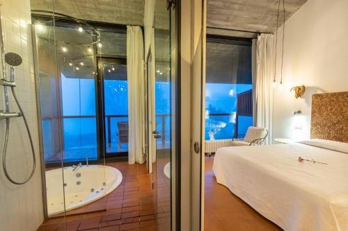 een slaapkamer met een bad, een bed en een douche bij Suites Niditas in Yuso