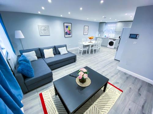a living room with a blue couch and a table at Spacious 2-Bedroom Flat in London - F3 in London