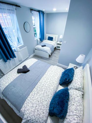 a bedroom with two beds with blue walls at Spacious 2-Bedroom Flat in London - F3 in London