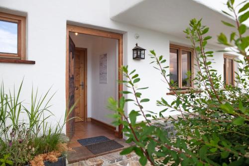 an open door to a white house with plants at Bergnest Penning in Hopfgarten im Brixental