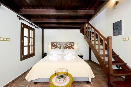 a bedroom with a bed and a staircase at Elaia-Fos in Rhodes Town