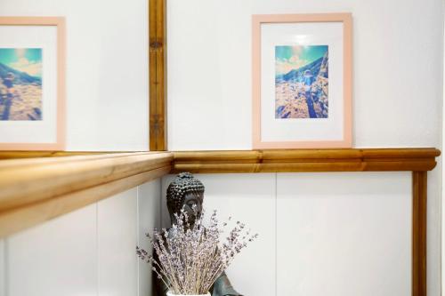 a shelf with three pictures and a vase with flowers at Bergnest Penning in Hopfgarten im Brixental