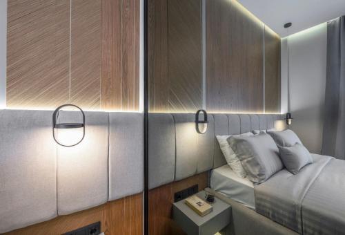 a bedroom with a bed and two lights on the wall at Aristotelian Virtues - Tharros in Thessaloniki