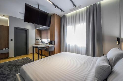 a hotel room with a bed and a kitchen at Aristotelian Virtues - Tharros in Thessaloniki