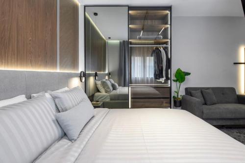 a bedroom with a white bed and a living room at Aristotelian Virtues - Tharros in Thessaloniki