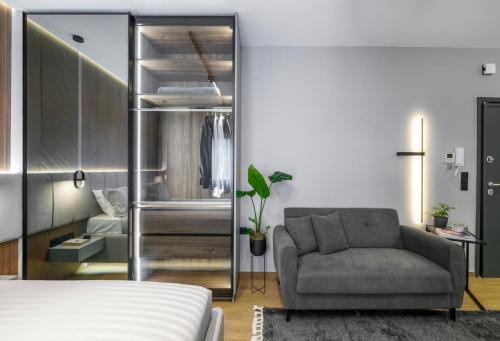 a bedroom with a bed and a couch and a chair at Aristotelian Virtues - Tharros in Thessaloniki