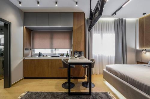 a room with a bed and a kitchen with a table at Aristotelian Virtues - Tharros in Thessaloniki