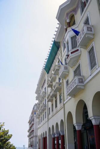 a large white building with red doors and windows at Aristotelian Virtues - Tharros in Thessaloniki