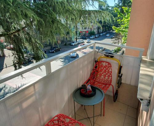 a balcony with a red chair and a table at Apartment Medea Batumi in Batumi