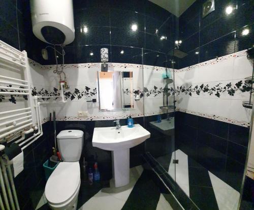 a black and white bathroom with a toilet and a sink at Apartment Medea Batumi in Batumi