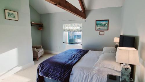 a bedroom with a large bed and a window at Edensor Cottage Bakewell Peak District in Bakewell