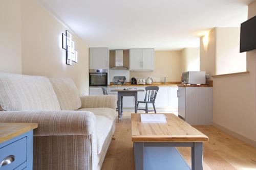 ein Wohnzimmer mit Couch und Küche in der Unterkunft Dunsa Cottage Bakewell Peak District in Bakewell