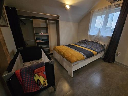 a small bedroom with a bed and a window at O'Pains d'Epices in Horbourg