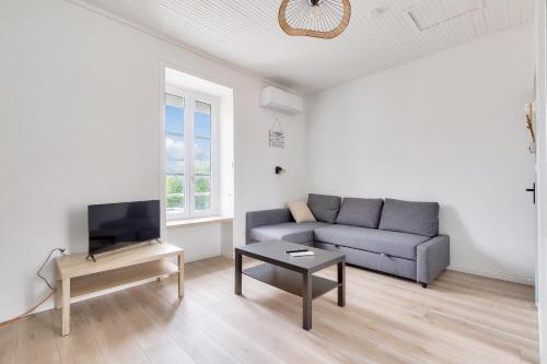 un salon avec un canapé et une télévision dans l'établissement Studio 2 personnes quartier de La Chaume, à Les Sables-dʼOlonne