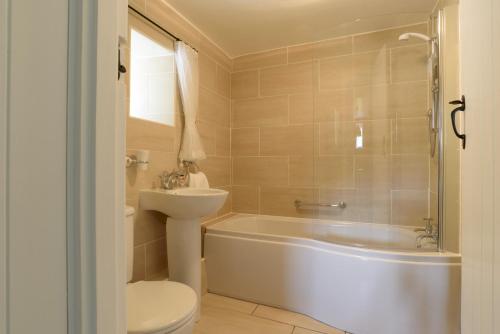 une salle de bain avec une baignoire, des toilettes et un lavabo dans l'établissement Greenhills Cottage Upperdale Peak District, à Buxton