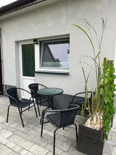 a patio with chairs and a table and a window at Apartament ogrodowy in Miechów
