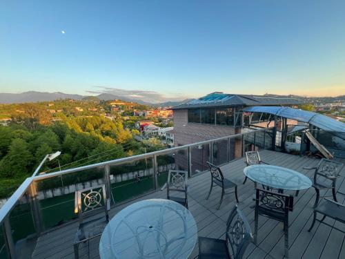 a balcony with tables and chairs on top of a building at BST Holiday in Batumi