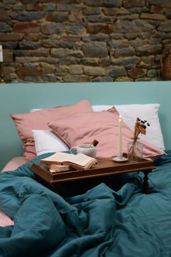 a table with a candle on top of a bed at Les Pierres Mont-Saint-Michel in Servon