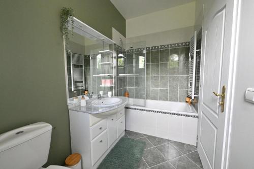 a bathroom with a sink and a tub and a toilet at Villa MANSART in Ver-sur-Launette
