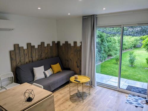 salon z kanapą i dużym oknem w obiekcie Jolie petite maison w mieście Sanguinet