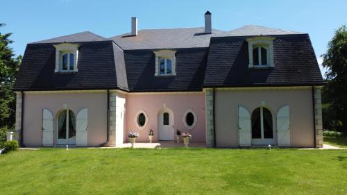 a house with a black roof and a green yard at Villa MANSART in Ver-sur-Launette