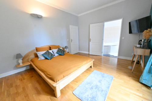 a bedroom with a bed with blue pillows on it at Villa MANSART in Ver-sur-Launette