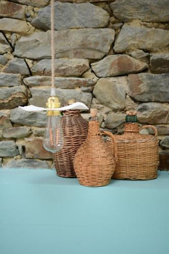 four baskets sitting on a shelf in front of a stone wall at Les Pierres Mont-Saint-Michel in Servon