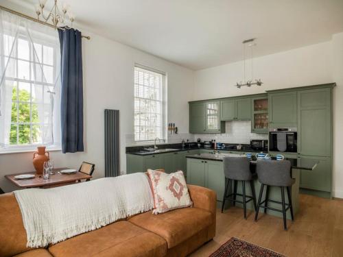 a living room with a couch and a kitchen at Regency Style Marvel Apartment 1-Bedroom Apartment in Gloucester with Parking in Gloucestershire