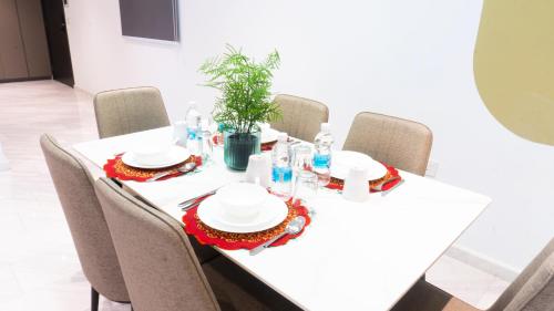 a table with chairs and a white table with a plant on it at MOONWAY SUITES At EATON KLCC in Kuala Lumpur