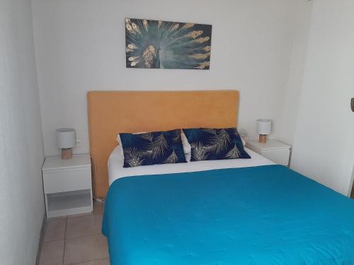 a bedroom with a blue bed with two night stands at Le 10 18 hôtel restaurant in Sainte-Croix-de-Verdon