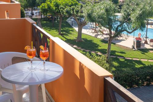 a table on a balcony with two drinks on it at Portokali Apartments in Hersonissos