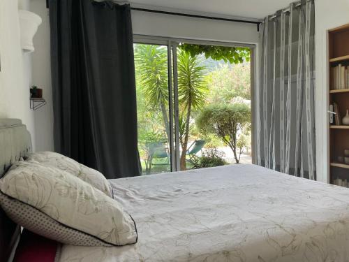 une chambre avec un lit et une grande fenêtre dans l'établissement Emeraude 2.0, à Rayol-Canadel-sur-Mer