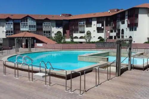 une piscine dans un hôtel avec des bâtiments en arrière-plan dans l'établissement Hossegor Vue Océan, à Soorts-Hossegor