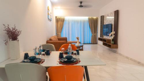 a living room with a table and orange chairs at MOONWAY SUITES At EATON KLCC in Kuala Lumpur
