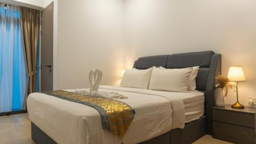 a bedroom with a large bed with white sheets at MOONWAY SUITES At EATON KLCC in Kuala Lumpur