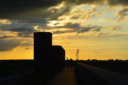 a group of people walking on a bridge at sunset at Komfortable Apartments in der Villa Eule in Varel